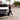 Luxe Creme elastic shoelaces in a stylish setting with a woman walking near a white SUV.