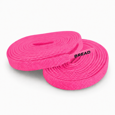 Two coiled neon pink fabric shoelaces with BREAD printed on the plastic tip.