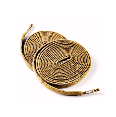 Coyote brown elastic shoelaces, coiled neatly, featuring a textured surface and a branded tip.