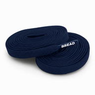 Two coiled navy blue fabric shoelaces with BREAD printed on the clear plastic aglet.