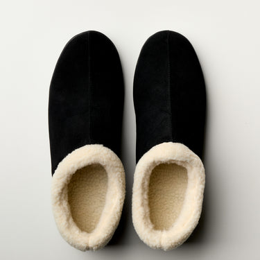 Men's Ashton slipper in black suede with a cream-colored faux fur lining, viewed from above.